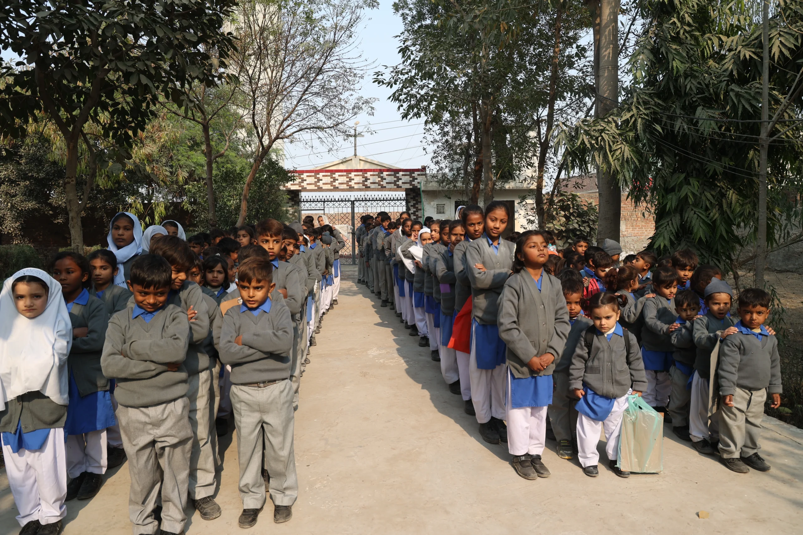 Christian children in MinorCare school uniforms standing together during school assembly.