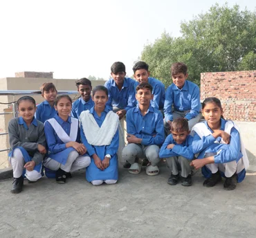 Christian boys smiling and studying together inside a MinorCare classroom in Pakistan.