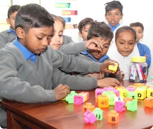 Christian children playing with colorful puzzle blocks inside a MinorCare classroom in Pakistan.