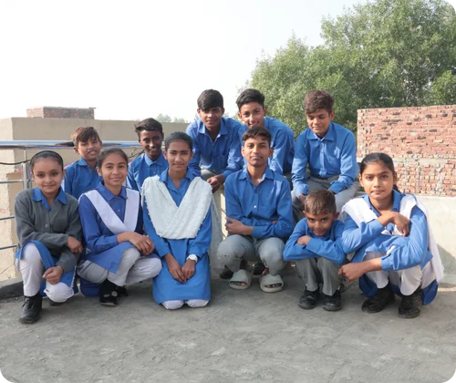 Christian children in MinorCare school uniforms sitting on their knees inside their classroom in Pakistan.