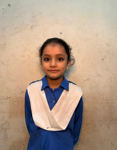 Aina Shehzad, a Christian student supported by MinorCare, smiling in her Grade 3 classroom in Pakistan.