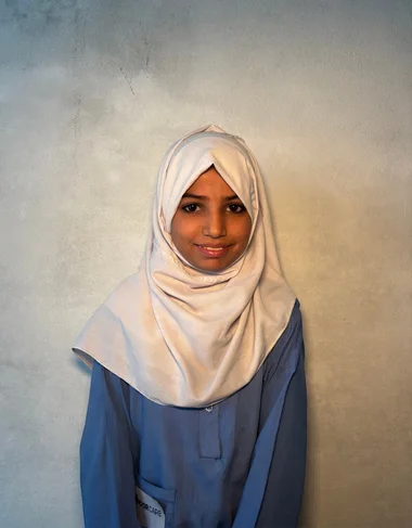 Amina Iqbal, a Christian Grade 2 student supported by MinorCare, smiling in her classroom in Pakistan.