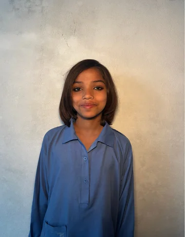 Anum Iqbal, a Christian Grade 2 student supported by MinorCare, smiling in her classroom in Pakistan.