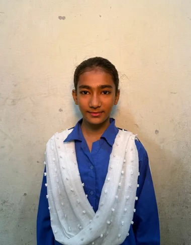 Arooj Naveed, a Christian Grade 6 student supported by MinorCare, smiling in her classroom in Pakistan.
