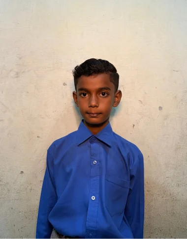 Ayan Naveed, a Christian Grade 6 student supported by MinorCare, smiling in his classroom in Pakistan.