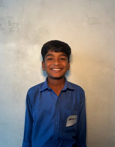 Barnabas Bashir, a Christian Grade 2 student supported by MinorCare, smiling in his classroom in Pakistan.