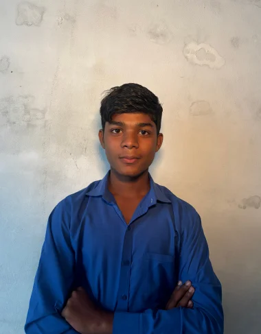 Faris Tariq, a Christian Grade 5 student supported by MinorCare, smiling in his classroom in Pakistan.
