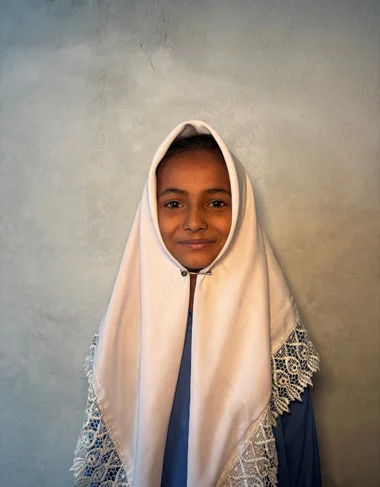 Iman Fatima Rafique, a Christian Grade 2 student supported by MinorCare, smiling in her classroom in Pakistan.