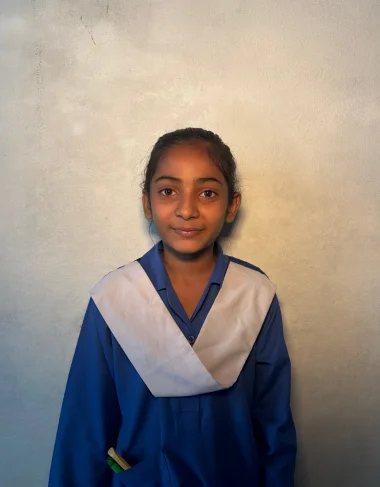 Iram Gulam, a Christian Grade 5 student supported by MinorCare, smiling in her classroom in Pakistan.