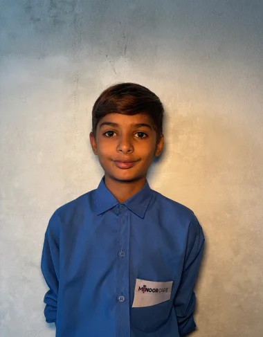 Jahanzaib Azar, a Christian Grade 5 student supported by MinorCare, smiling in his classroom in Pakistan.