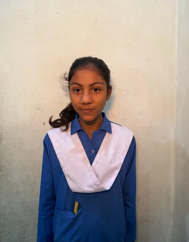 Jennifer, a Christian Grade 4 student supported by MinorCare, smiling in her classroom in Pakistan.