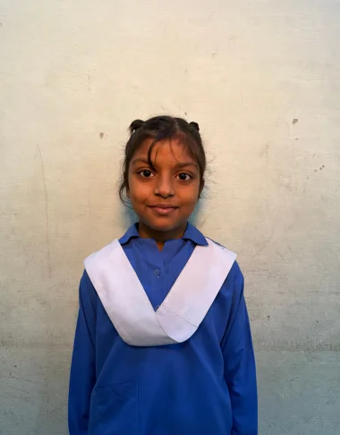 Joina, a Christian Grade 4 student supported by MinorCare, smiling in her classroom in Pakistan.