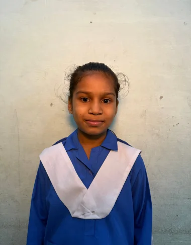 Kinza Ashraf, a Christian Grade 4 student supported by MinorCare, smiling in her classroom in Pakistan.