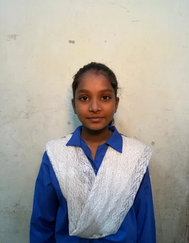 Mehwish, a Christian Grade 6 student supported by MinorCare, smiling in her classroom in Pakistan.