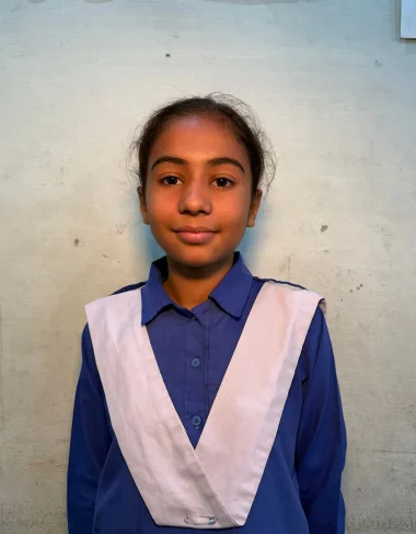 Saira Mansha, a Christian Grade 4 student supported by MinorCare, smiling confidently in her classroom in Pakistan.