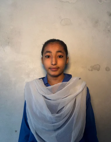 Samra, a Christian Grade 5 student supported by MinorCare, smiling in her classroom in Pakistan.